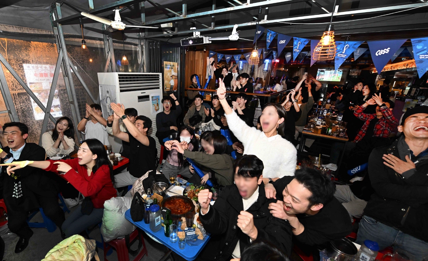오비맥주 카스 브랜드와 함께 스포츠 경기를 시청하며 열정적으로 응원하는 사람들 모습