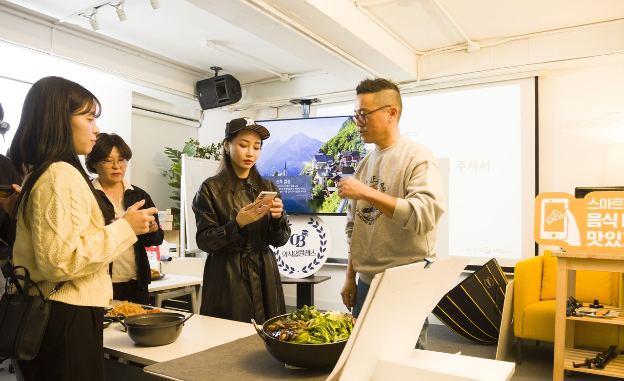 오비맥주 의식의 클래스에서 참가자들이 스마트폰으로 음식을 촬영하며 체험하는 모습